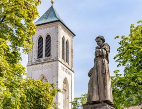 Turm der Martinskirche mit Bäumen davor 