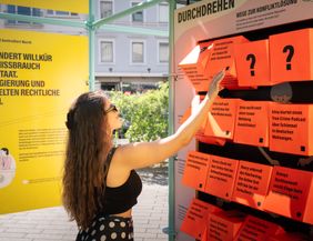 Ein Frau dreht an einem Würfelspiel der Ausstellung