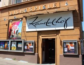 Eingang des Kinos Kandelhof in Freiburg mit Filmplakaten an der Fassade.