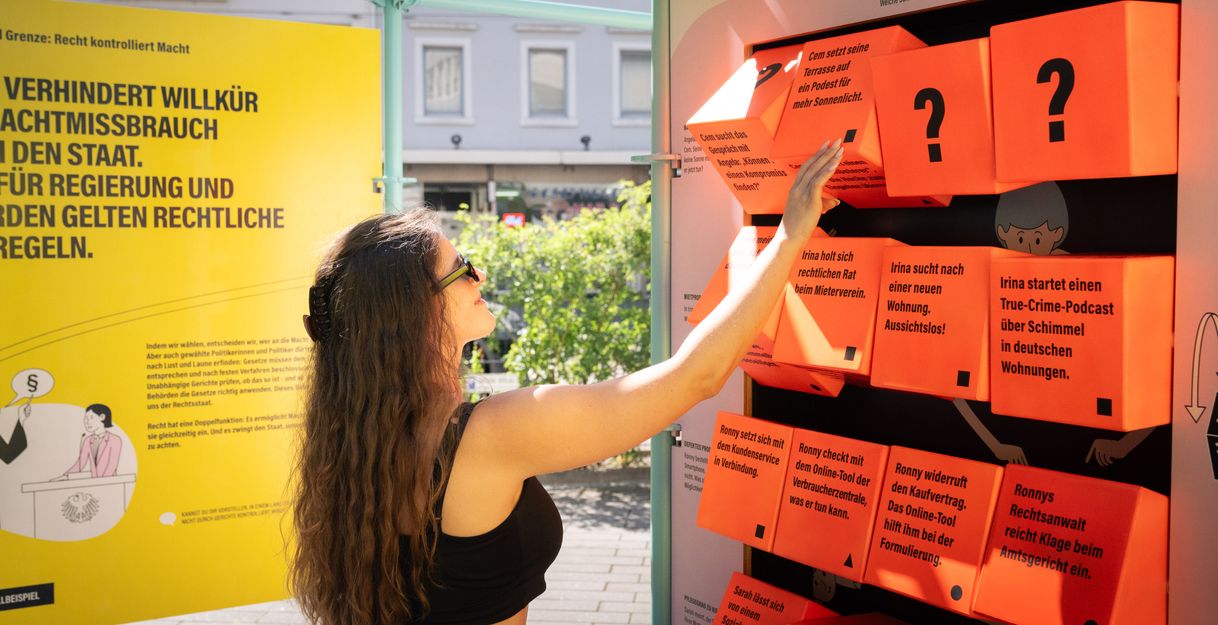 Ein Frau dreht an einem Würfelspiel der Ausstellung